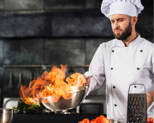 Chef waving a pan and causing flames in it